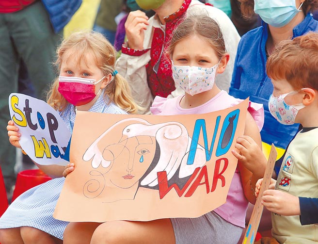 图为外国小朋友拿着反战标语力挺乌克兰。（刘宗龙摄）