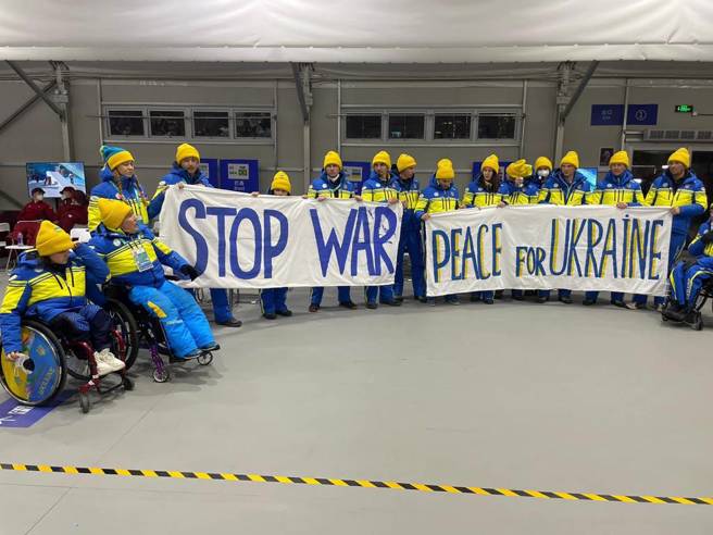 烏克蘭冬季帕運選手舉著反戰標語。（美聯社）