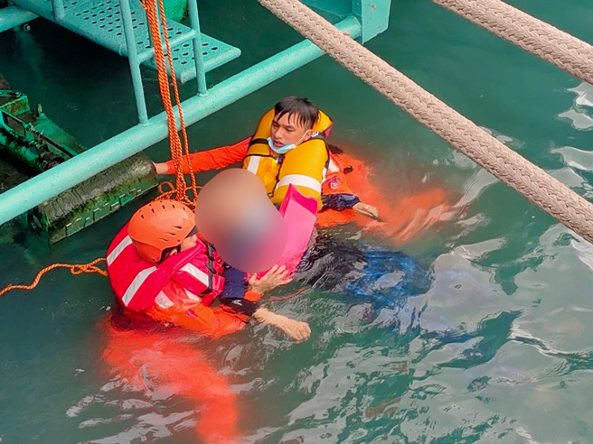 海巡署伽蓝渔港安检所人员，携带鱼雷浮标及救生圈装备下水，救援落海民眾。（海巡署提供）