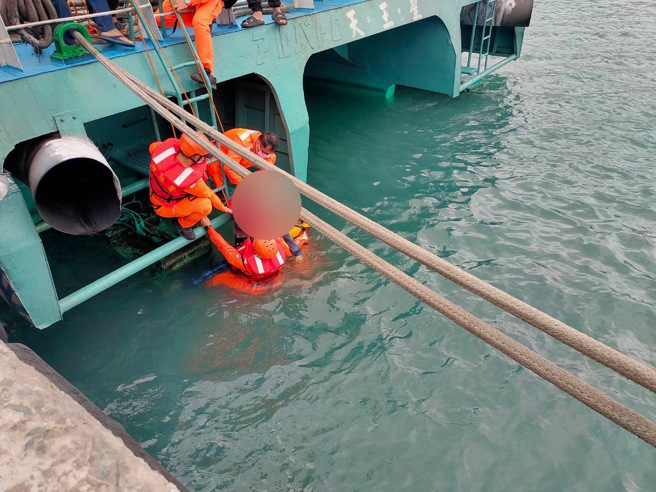 海巡署伽蓝渔港安检所人员，携带鱼雷浮标及救生圈装备下水，救援落海民眾。（海巡署提供）