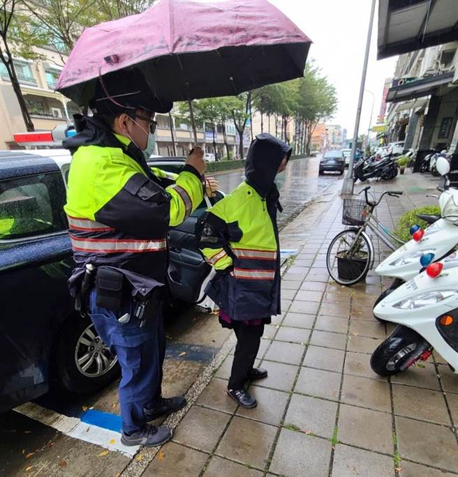 警方将身穿警察雨衣的卢姓妇人带回派出所。（翻摄照片／石秀华高雄传真） （陈家蓁提供／石秀华高雄传真）