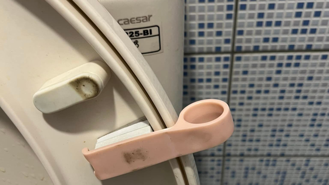 一名男網友到超商上廁所時，發現馬桶蓋上夾著一個粉紅圓形鏤空小把手，卻不解其用意，有知情網友解惑，「掀馬桶蓋用的衛生掀」。（圖／翻攝自爆廢公社二館）