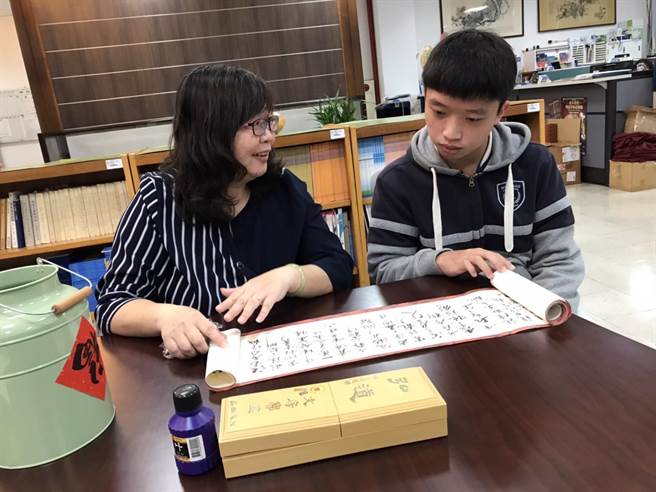 明道中學文化創意處林雯琪副校長（左）勉勵榮獲台積電青年書法大賞篆隸楷組首獎的學生楊翊詮，「找到生命抒發的出口，是很美好的」。（明道中學提供／盧金足台中傳真）