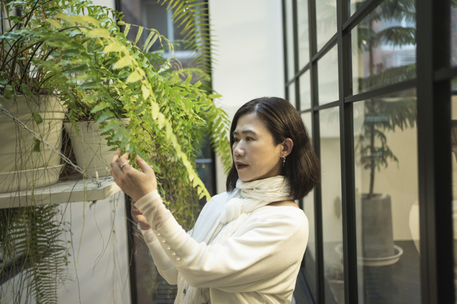 观赏美丽的植物能让彭树君心情舒畅，激发书写灵感。(摄影/陈志诚)