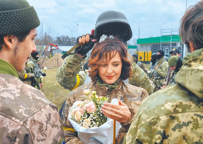 俄乌战事炮火持续，乌克兰1名士兵6日在基辅附近的管制站完成婚礼，并以头盔作为结婚王冠。（美联社）