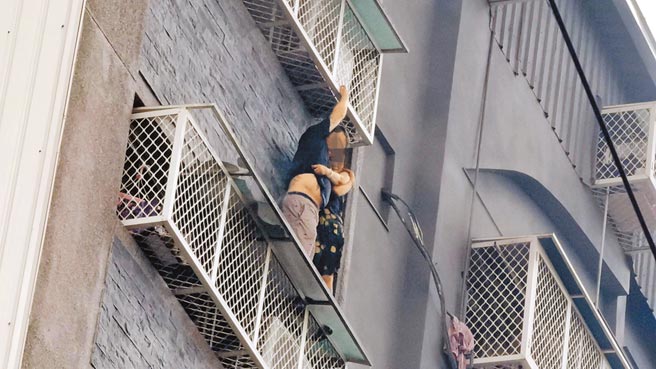 台中市兴中街大楼大火酿成6死6伤，检警7日重回火场调查，发现房东庄妇在楼梯间及大门前堆放大批杂物、各层楼梯间违法装设铁门、未设安全门，不但助长火势，更阻碍逃生及救援。这场恶火来得又猛又急，6楼住户情急爬出铁窗，冒险挤踩在遮雨棚大喊救命（见图）。（中新社）