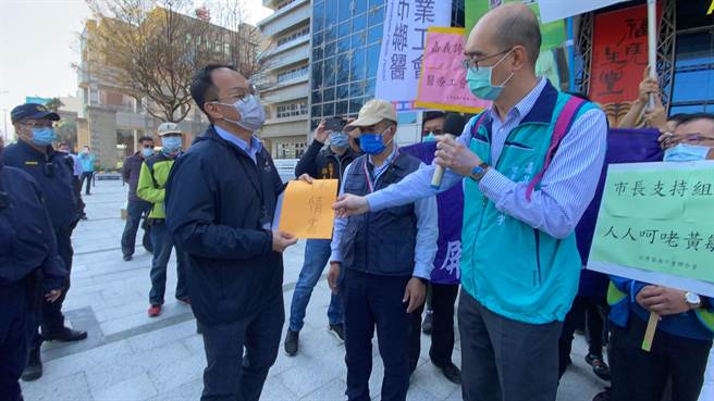 台灣醫療工會聯合會今天到嘉義市政府抗議，理事長趙麟宇送陳情書，市府社會處長林家緯代表收下。（廖素慧攝）