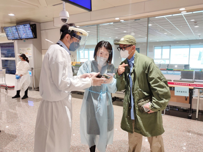 具俊曄稍早經由寰宇商務中心工作人員協助用手機申報健康聲明書。（圖／陳麒全攝）