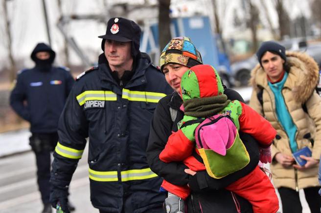 一名母親抱著小孩，從烏克蘭逃往羅馬尼亞。（路透）