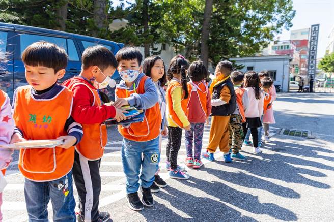 金門金湖國小附設幼稚園「戴勝書屋」啟用，幼生以人龍接力方式傳送書籍，攜手為打造自己的閱讀新城堡盡一分心力。（湖小提供）