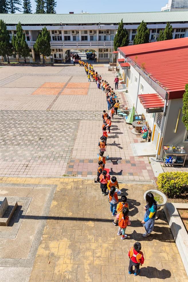 金門金湖國小附設幼稚園「戴勝書屋」啟用，幼生以長達200公尺的人龍接力方式傳送書籍。（湖小提供）