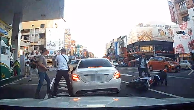 影片中，白色賓士車停在加油站旁準備離開，突然遭5、6名員警上前攔查，駕駛一度拒絕接受盤查，警方隨即朝車開槍，賓士車一度想加速駛離遭不斷開槍。（民眾提供）