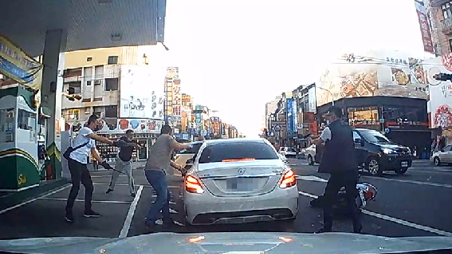 影片中，白色賓士車停在加油站旁準備離開，突然遭5、6名員警上前攔查，駕駛一度拒絕接受盤查，警方隨即朝車開槍，賓士車一度想加速駛離遭不斷開槍。（民眾提供）