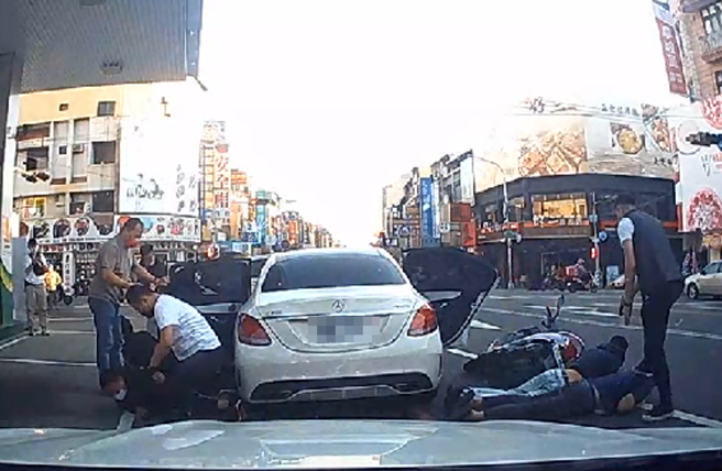 影片中，白色賓士車停在加油站旁準備離開，突然遭5、6名員警上前攔查，駕駛一度拒絕接受盤查，警方隨即朝車開槍，賓士車一度想加速駛離遭不斷開槍。（民眾提供）