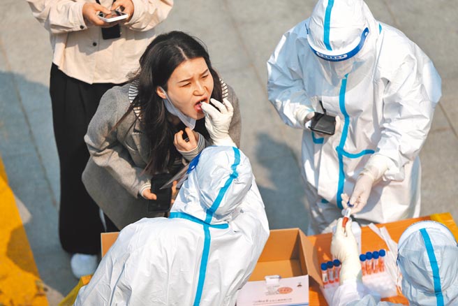 大陸全國「兩會」即將落幕之際，境內疫情再度升溫。圖為陝西西安的市民接受核酸檢測。（中新社）