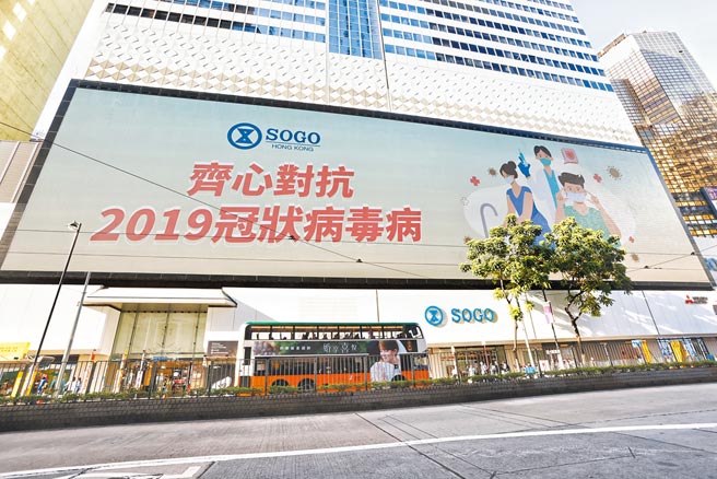 香港第5波疫情严峻，铜锣湾SOGO外墙萤幕打出巨型标语，呼吁市民齐心对抗新冠病毒。在北京出手支援下，香港疫情有自高峰趋缓。（中新社）