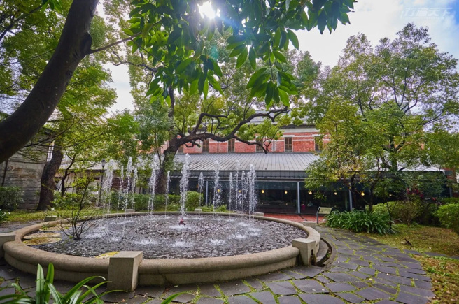 戶外大片樟樹林與噴水池，對都會人來說是珍貴的療癒放鬆之處。(圖/行遍天下)