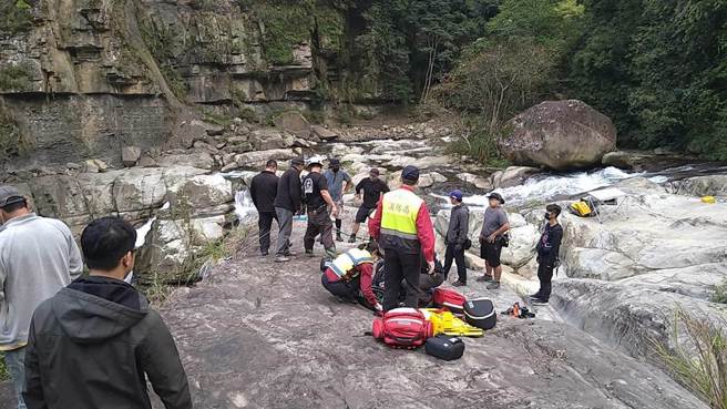 苗栗县南庄乡鹿场部落神仙谷11日下午发生 2名摄影师坠潭溺毙意外，救难人员以人力将落潭者搬运上方坡地。（读者提供／谢明俊苗栗传真）
