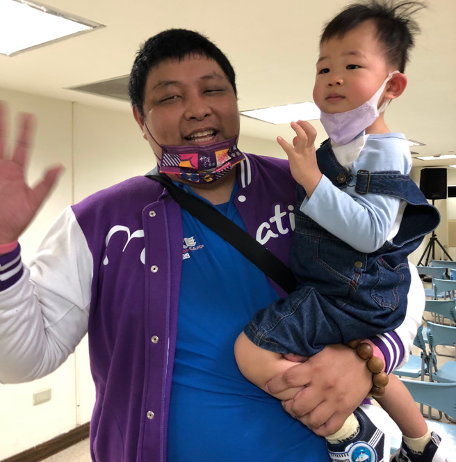 光復高中教头陈定杰抱着儿子出席赛后记者会。（陈筱琳摄）