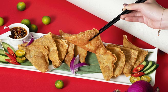 〈印尼炸鱼馄饨〉俗称「印尼烧卖」，将馄饨皮包裹着鱼浆及辛香料下去油炸至金黄色，吃的时候沾上混入甜酱油及辣椒碎的花生酱，口感丰富多层次。　图／台北远东香格里拉饭店