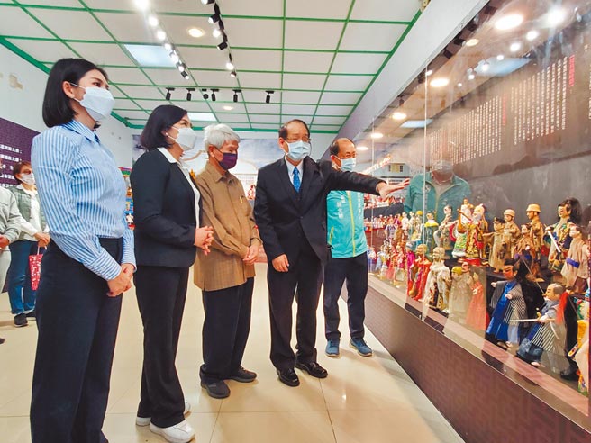 锺任壁大师儿子、新兴阁掌中剧团第6代传人锺任梁（右二）为县长张丽善（右四）、已故布袋戏大师黄海岱之五子黄逢时（右三）导览父亲生前收藏的新兴阁各时期布袋戏文物。（周丽兰摄）