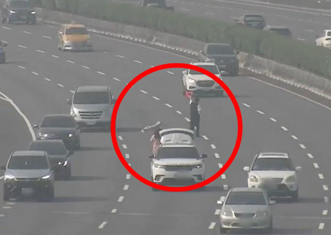 有网友分享朋友的父母开车上国道时车辆抛锚，朋友父母径自下车，在车阵中挥舞警示牌。（翻摄自脸书社团《爆料公社公开版》）