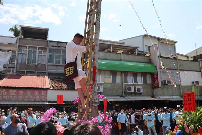 43岁的林振贤师承其父林青云道长，在上千乡亲见证下，攀登36层刀梯，通过考验晋陞道长。（刘秀芬摄）