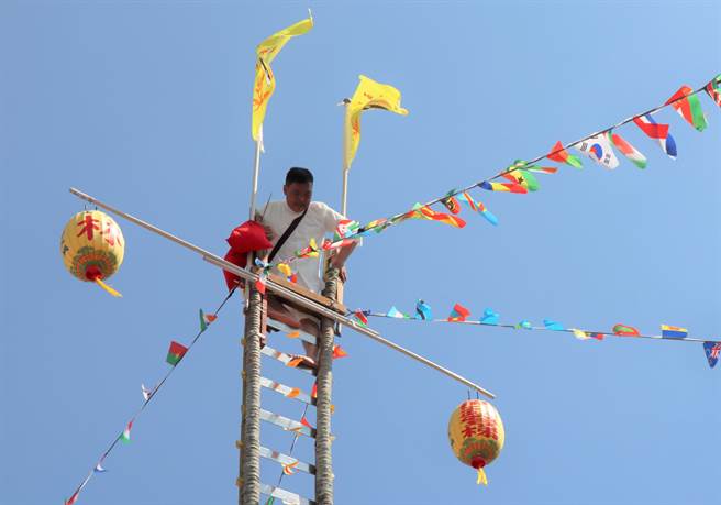 43岁的林振贤师承其父林青云道长，在上千乡亲见证下，攀登36层刀梯，通过考验晋陞道长。（刘秀芬摄）