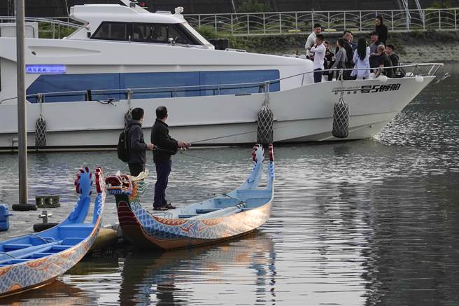 一艘「舶爵五号」游艇行经台北剑潭段基隆河水域，与三脚渡浮动码头边的传统龙舟形成传统与现代的对比。（黄子明摄）