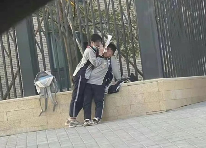 一名小女孩压在小男孩上写功课，特殊姿势被网友拍下PO网，引发热议。（翻摄自脸书爆废公社公开板）