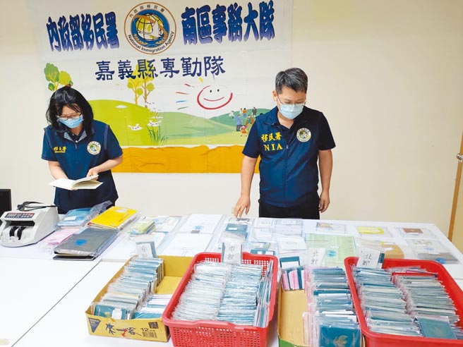 移民署嘉義縣專勤隊移民官檢視搜索扣押的342本護照、帳冊、點鈔機等證物。（嘉義縣專勤隊提供／張亦惠嘉縣傳真）