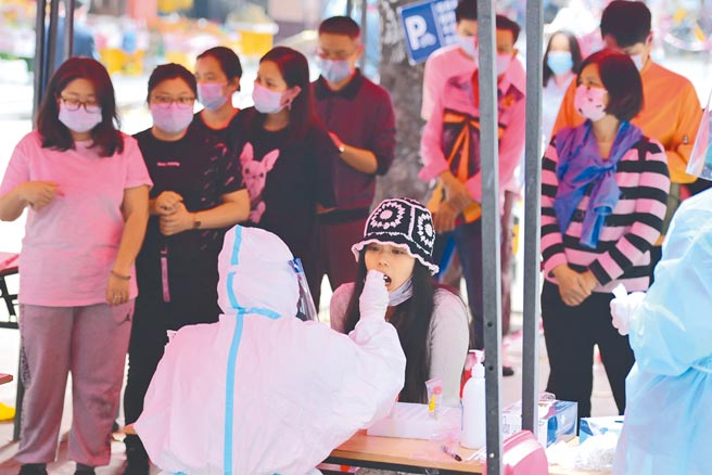 中国（广州）国际美博会展馆，因出现一疑似新冠检测阳性人员，採取临时封闭管控。图为广州民眾排队做核酸检测。（中新社）