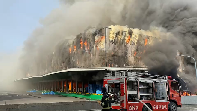 桃園市幼獅工業區14日上午8時許一處廠房發生大火，現場火勢猛烈伴隨濃濃黑煙直衝天際。（翻攝自記者爆料網）
