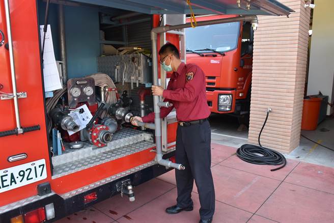 造桥分队长蔡宗勲亲自示范安装消防衣清消器，非常简便快速接装在水箱车出水接头上。（谢明俊摄）