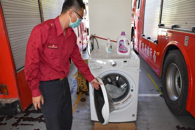 勤后返回分队部，立即以滚桶式洗衣机清洗消防衣。（谢明俊摄）