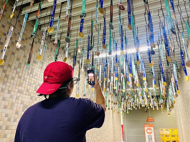 萬金石馬拉松賽前運動博覽會用歷屆獎牌懸掛而成的萬金石隧道迎賓。（新北市體育處提供）