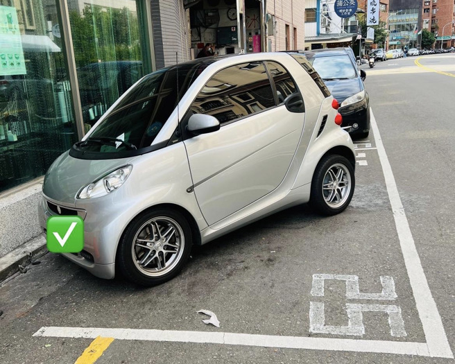 一名女网友发现一辆斜停进路边停车格的小车，忍不住讚嘆「车子小就是狂」。（图／翻摄自脸书社团爆废公社）