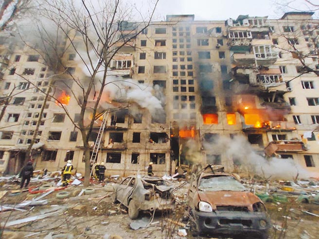 救援人員在烏克蘭基輔一棟被砲擊損壞的住宅旁邊工作。（路透）