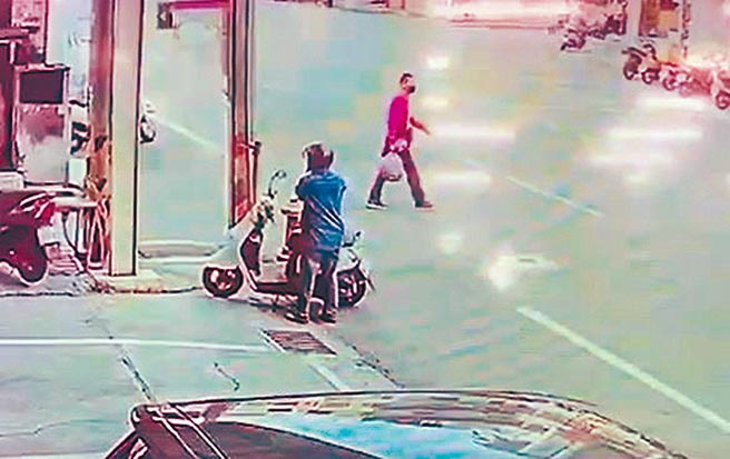 彭男在行凶后，手拎一包疑似放有凶刀物品，若无其事过马路。（罗浚滨翻摄）