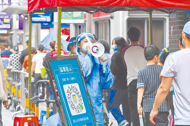 广东深圳14日起全市封闭式管理7天，公车地铁停运。图为防疫人员引导民眾做核酸检测。（新华社）