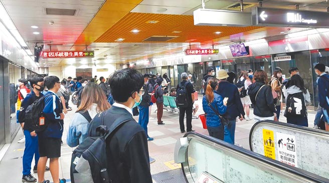 高捷14日上午因号志异常停驶20分，让不少赶着上学上班的学生和通勤族在捷运站内排队枯等，不少人边等边滑手机打发时间。（翻摄照片／石秀华高雄传真）