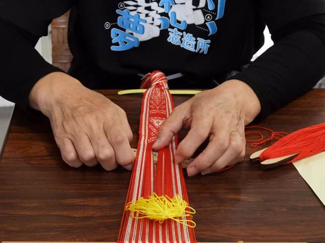 花莲林荣游憩区转型成「慢城客家驿站」，进驻馆内的织布工艺师在现场织出一条象徵原客共荣的纹路。（罗亦晽摄）