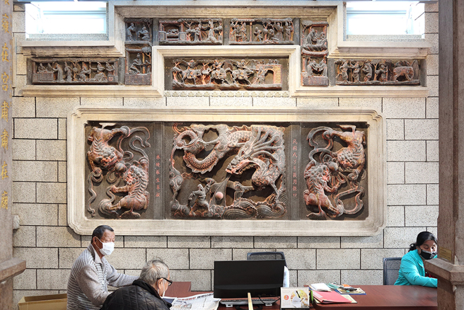 「龍虎堵石雕牆」為中西合併的設計，展現旗津的商埠文化。廟內石雕牆除了中式傳統龍、虎之外，當時的匠師在上方的水車堵帶入西式風格。(攝影/Carter)