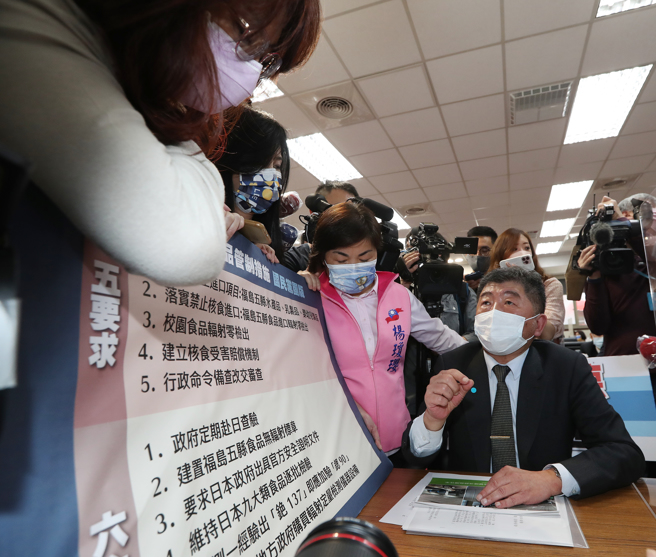 国民党立委郑丽文、杨琼璎拿着日本进口食品管制措施国民党团版的五要求、六主张，围在卫福部长陈时中身旁，要求陈时中回覆。（刘宗龙摄)