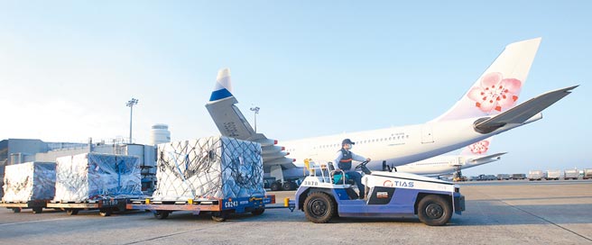 中華航空15日公告2021全年營收達新台幣1388.41億元，其中貨運收入更以1245億元創62年來最高紀錄，在桃園機場的停機坪上，地勤人員忙著卸下班機上的貨物。（范揚光攝）