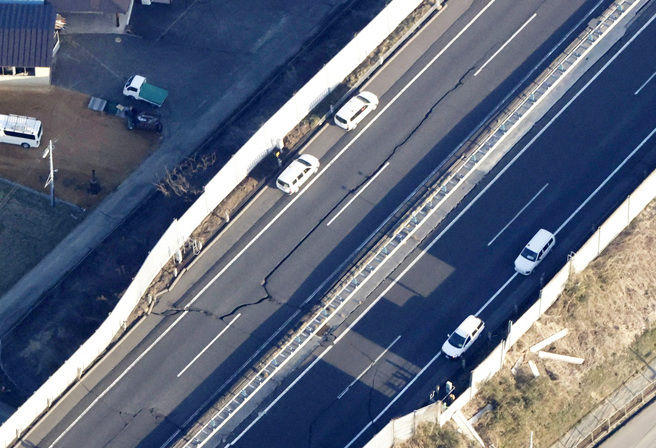 日本东北7.4强震造成白石市一座高速高路路面出现超长巨大裂缝。（图／路透社、共同社）