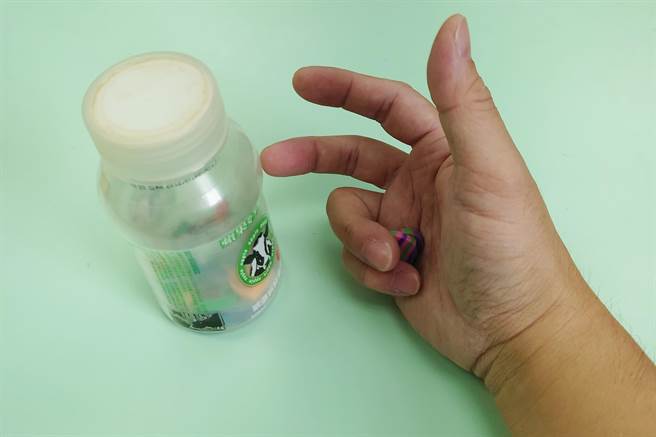 进行3换转瓶盖螺丝的游戏时，需先以无名指及小姆指抓握住小橡皮擦物件再进行（台北医院提供／戴上容新北传真）