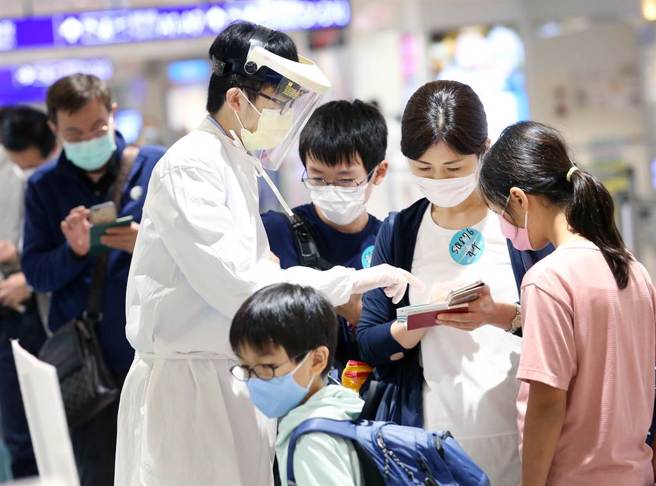 在桃園機場第二航廈的入境管制區內，防疫人員協助旅客上網申報入境檢疫憑證。（范揚光攝）（圖中非新聞當事人）
