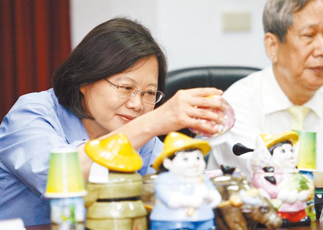 农委会预告《农会法》修正，将增列中央主管机关指派专业理事。图为蔡英文总统2015年选前拜会新竹市农会时，把玩桌上玩偶。（本报资料照片）