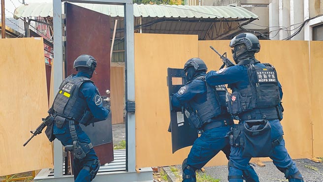 高雄保安警察大队大特勤中队全副武装，持破坏器及枪枝和盾牌演练攻坚。（洪靖宜摄）